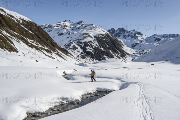Ski tourers on the Graubünden Haute Route in the Val Susauna mountain valley, snow-covered