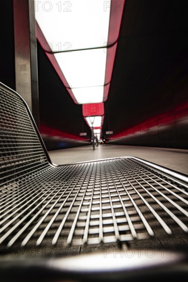 Modern underground station with metal bench and red lighting effects, Hafencity University,