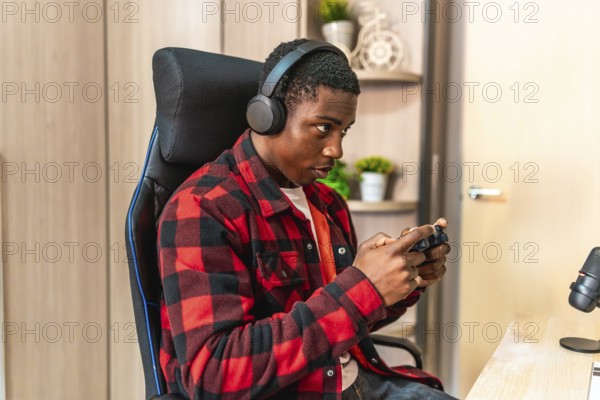 Young man engaging in video gaming and streaming online, wearing headphones and skillfully