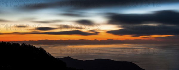 Atmospheric view with colourful evening sky shortly after sunset from Tuscan island Giglio to the
