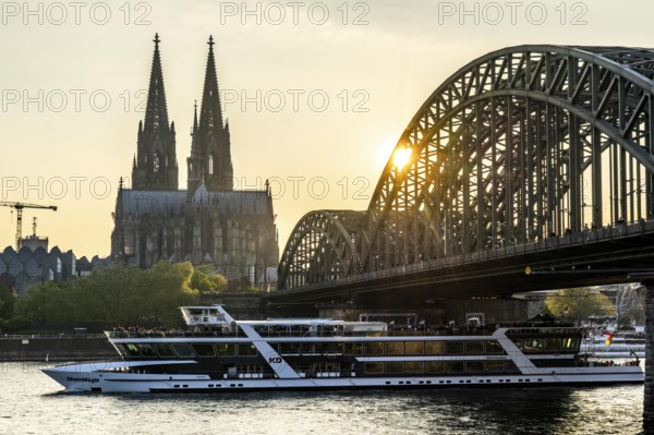 Silhouettes of the cathedral in late sunlight, freighter on the Rhine, view of Cologne Cathedral