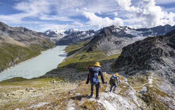 Two mountaineers on the summit of Mont de la Blana, view of a blue mountain lake, Lac des Dix