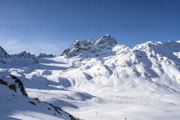 Mountain peak Piz Kesch with snow, view at the Kesch hut in winter, Grisons Haute Route, Albula