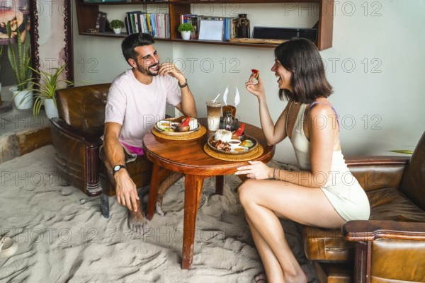 Tourists enjoying breakfast in a restaurant with sandy floor in siargao island, philippines, during