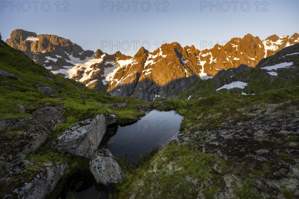 Rocky mountain peaks with reflection, small pond in moor landscape at Trollfjord Hytta, mountain