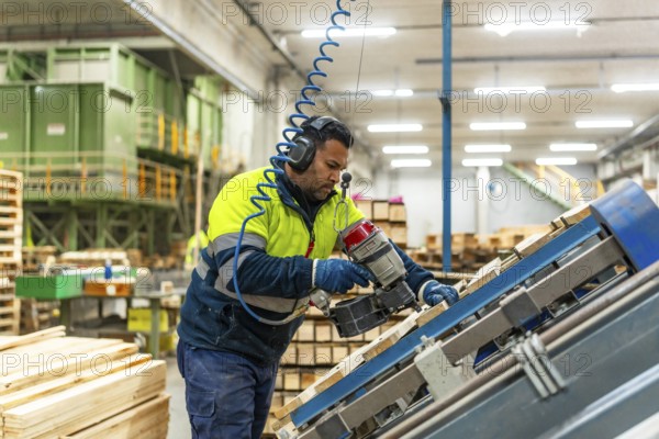 Side view three quarter length photo of a caucasian man worker arranging pallets to reuse it in a