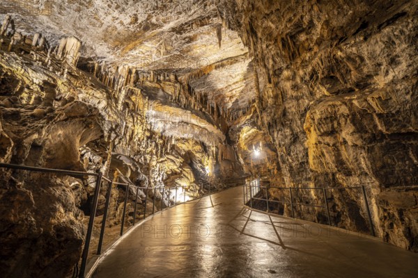 Tourists exploring the illuminated pathway within the breathtaking postojna cave, marveling at the