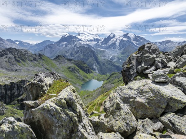 Mountain stream and mountain lake Lac de Louvie with glaciated summit of the Grand Combin, Val de