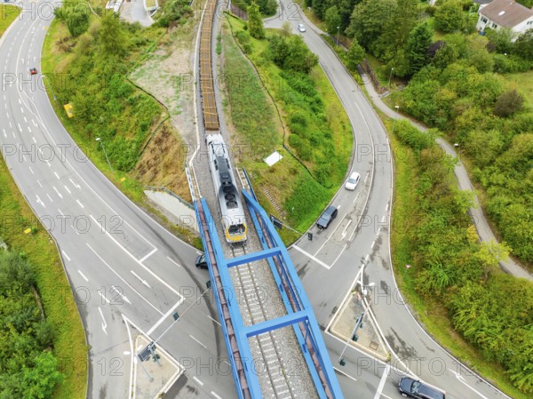 Railway train crosses a bridge with roads and vehicles, track construction, rail delivery for