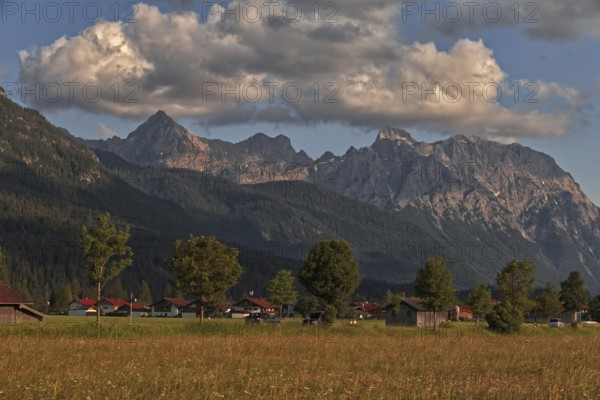 Mountains in the background of a small village with clouds in the sky in a natural landscape,
