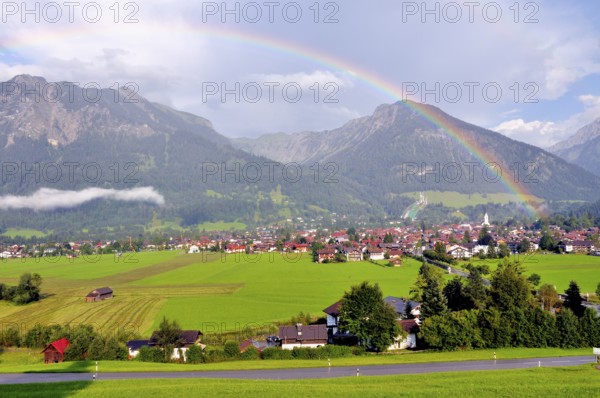 View over Oberstdorf with rainbow, behind it the Schattenberg with Schattenbergschanze, Oberallgäu,