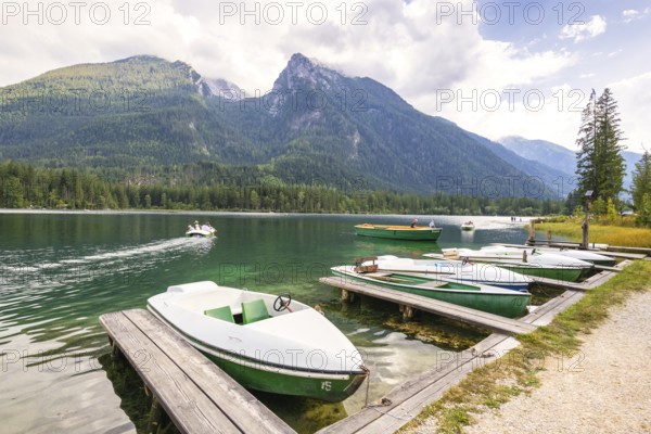 Jetty with boats at Hintersee, with green mountains in the background, peaceful and idyllic natural