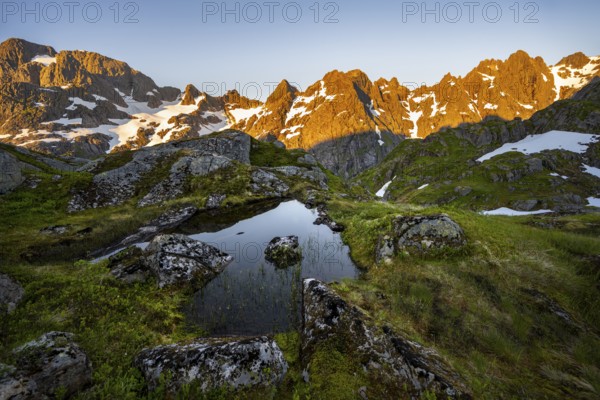 Rocky mountain peaks with reflection, small pond in moor landscape at Trollfjord Hytta, mountain