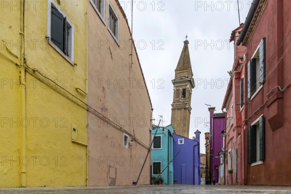 City view of Burano with colourfully painted houses and canals. Slate church tower Campanile,