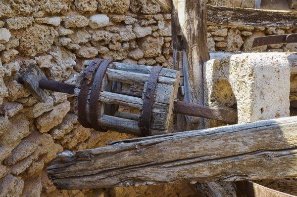 Close-up of a wooden cogwheel component in an old stone building ruin, windmill, ruin, near Lindos,