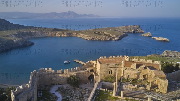 Drone shot, Acropolis of Lindos, Late afternoon light, Rock fortified historical site above a calm