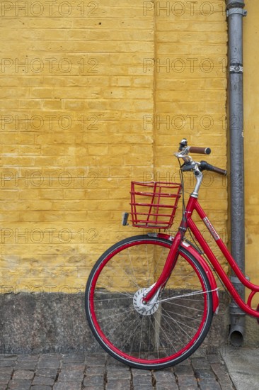 Red bicycle in front of yellow wall, heritage-protected building Søkvæsthuset, former naval