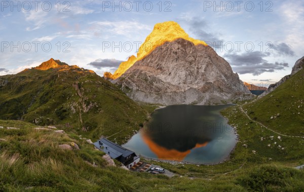 Alpenglow at Seekopf or Monte Capolago, reflection in Lake Wolayersee with Alpine Club hut