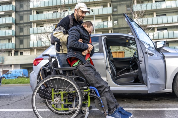 Man assisting disabled friend in getting out of a car parked on an urban street, showcasing the