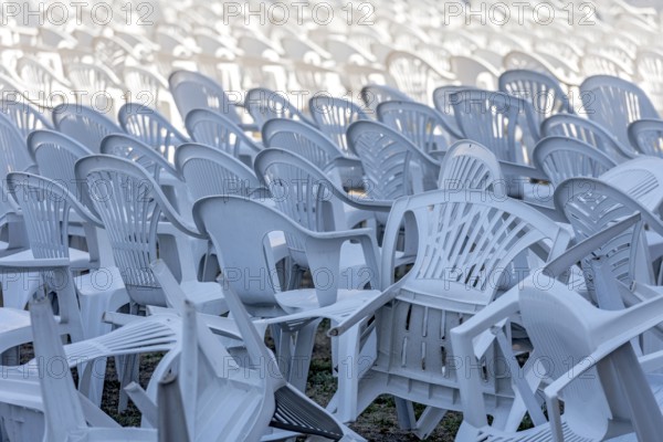 Seating for outdoor event, rows of chairs, overturned garden chairs made of plastic, plastic,