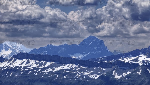 View of impressive mountain range with snow-covered peaks under dramatic clouds, Oberstaufen,
