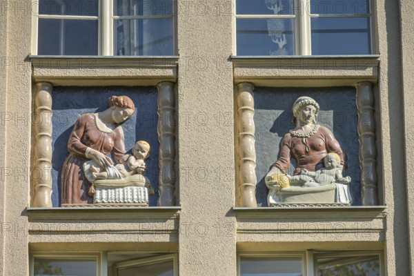 Mothers looking after their babies, relief on an old building, former woman's and children's