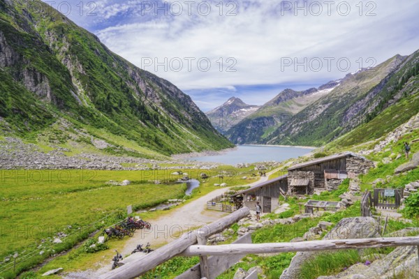View of a mountain landscape with a lake, huts and a path through a green meadow, Klein Tibet,