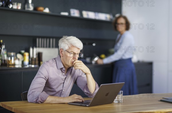 Symbolic photo on the subject of division of labour for couples in the household. A man sits in a