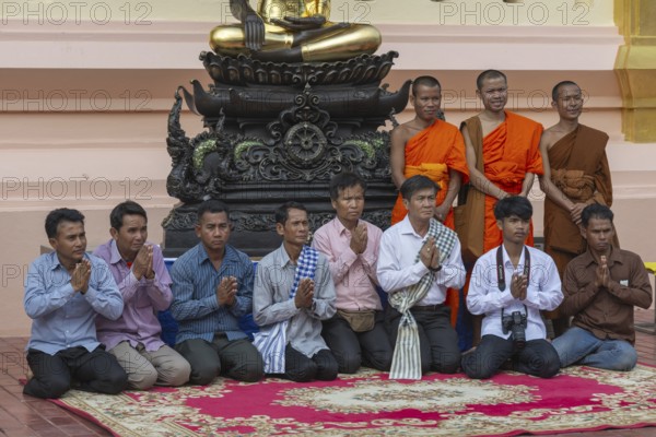 Monks and Laotians in front of a Buddha statue, Bhumispara-mudra, Buddha Gautama at the moment of