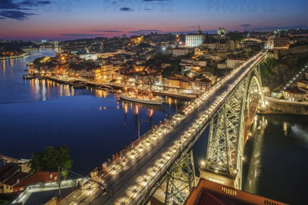View of illuminated Porto city and Douro river and Dom Luis bridge I from famous tourist viewpoint