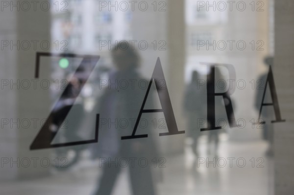 Company logo of the textile retail chain Zara, passers-by reflected in the shop window in Berlin,