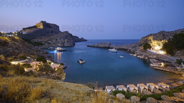 St Paul's Bay in the evening light, view of an illuminated bay with boats and calm water at dusk,