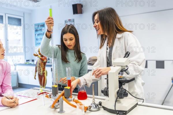 Female teacher assisting student using laboratory equipment during a chemistry experiment in a