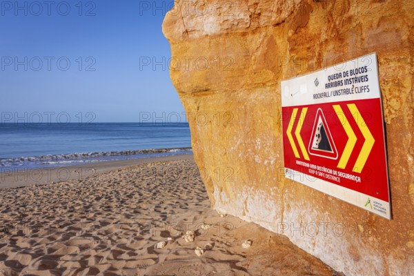 ROCKFALL UNSTABLE CLIFFS, KEEP A SAFE DISTANCE is written in English on a warning sign in Portugal