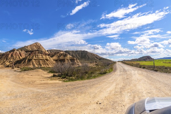 Scenic view of a dirt road winding through the geological formations of bardenas reales desert in