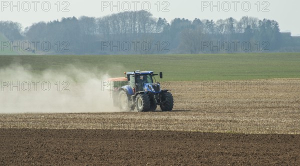 Spring farming, spreading fertilizer with tractor on field in Ystad municipality, Skåne county,