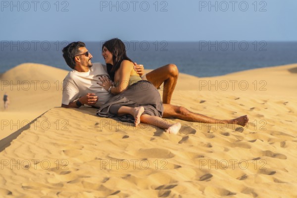 Tourists enjoying summer holidays lying on the sand in the maspalomas dunes, gran canaria, canary