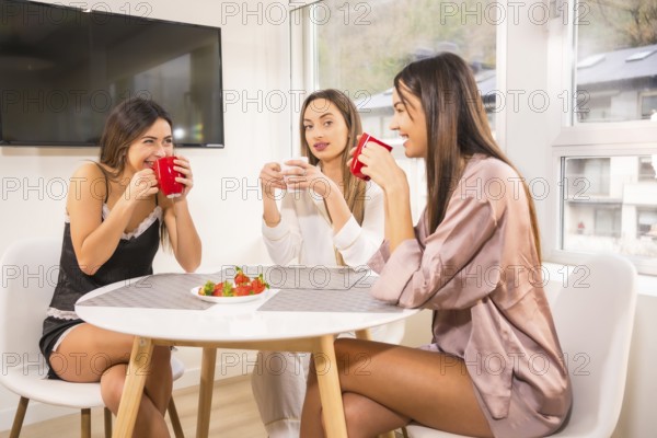 Lifestyle of Caucasian friends on vacation in a hotel having breakfast, dressed in nightwear and