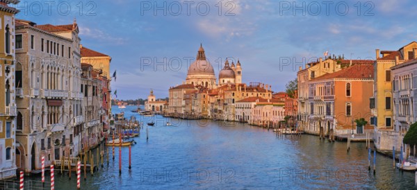 Panorama of Venice Grand Canal with boats and Santa Maria della Salute church on sunset from Ponte