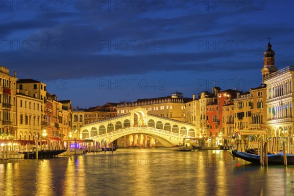 Famous Venetian tourist landmark Rialto bridge (Ponte di Rialto) over Grand Canal illuminated at