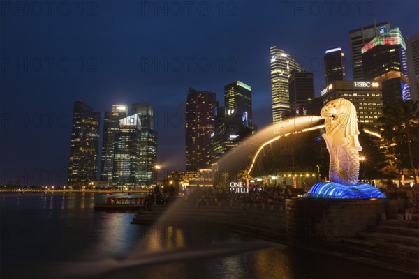 SINGAPORE, JANUARY 1, 2014: Night view of Singapore Merlion at Marina Bay against Singapore skyline