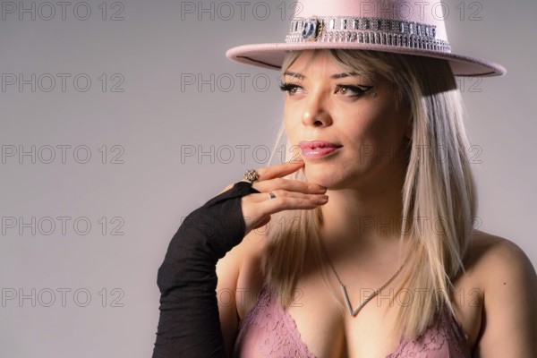Attractive young blonde woman with long hair, wearing a pink cowboy hat and a pink bra,