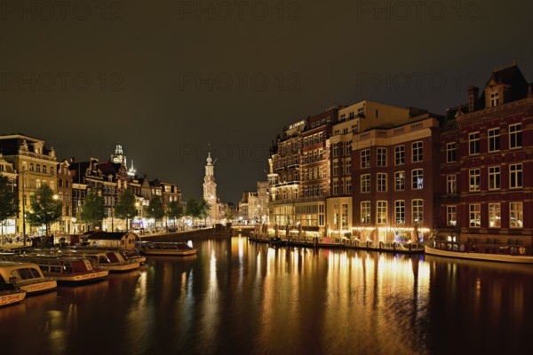 Historic buildings and mint tower illuminated at night, Singelgracht, Amsterdam, North Holland,
