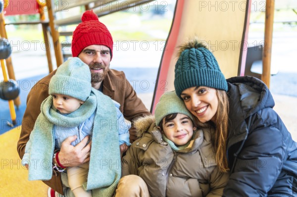 Happy family bundled in winter clothing, smiling and embracing joyfully while enjoying playful