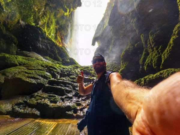 A tourist inside the Iris grotto at the Cola de Caballo Waterfall in the Monasterio de Piedra