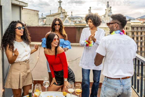 Woman dancing sensually latin music next to multi-ethnic friends in a rooftop party in the evening