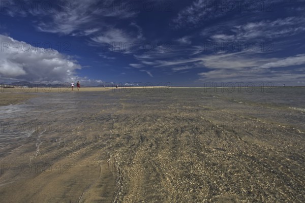 Wide beach Playa Risco del Paso, Playa de Sotavento with sea view, clouds in the blue sky and a