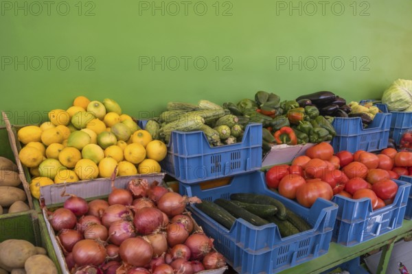 Market stall with various types of fruit and vegetables such as lemons, potatoes, onions, tomatoes,
