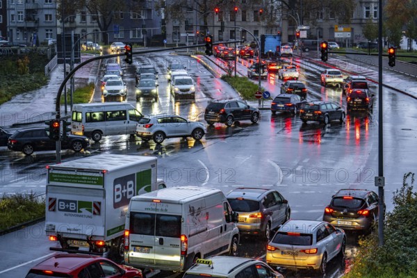 Rainy weather, road traffic, intersection, lights of vehicles on a wet road, traffic lights, tail