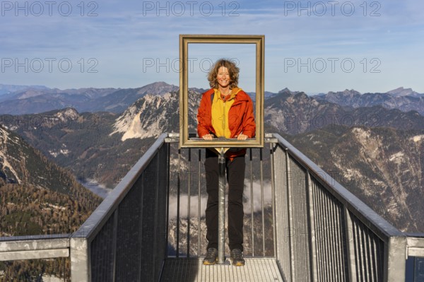 A hiker stands on the 5fingers viewpoint and looks through the picture frame. View from the